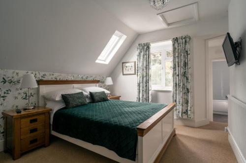林顿Lee House的一间卧室配有一张带绿色棉被的床