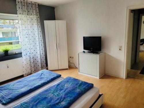 瓦尔多夫Appartment in Walldorf mit Schlafzimmer, Küche und Bad的一间卧室设有一张床、一台电视和一个窗口。