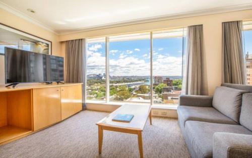 悉尼Holiday Inn Sydney Potts Point的带沙发和大窗户的客厅