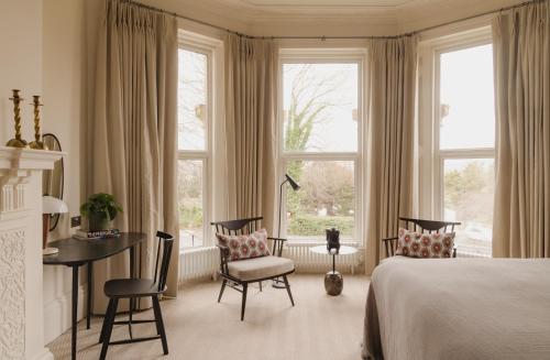 巴斯Leighton House - Boutique Guesthouse的卧室配有一张床、一张书桌和窗户。