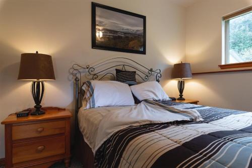 海恩斯Apartment Dolphin House的一间卧室配有一张带两盏灯的床,墙上挂着一张照片