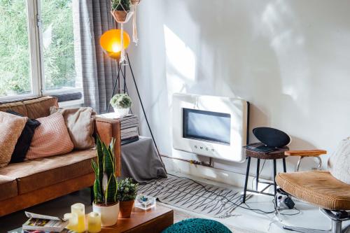 阿姆斯特丹珂珂玛玛旅舍的带沙发和电视的客厅