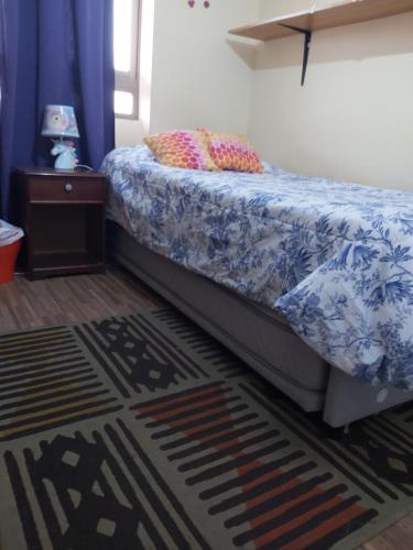 伊基克Habitación frente al mar的一间卧室配有一张带蓝色和白色棉被的床