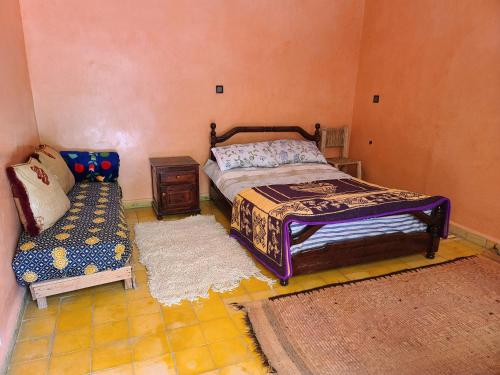 拉拉塔可库斯特Dar de l'Atlas的一间卧室配有一张床、一张桌子和一张沙发