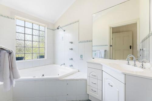纳鲁马12 Bluewater Drive Narooma的白色的浴室设有浴缸和水槽。