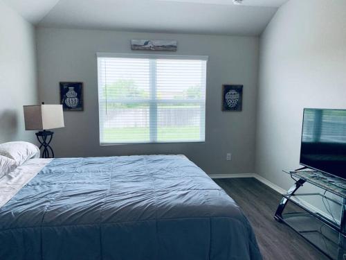 圣安东尼奥Cheerful three-bedroom home的一间卧室设有一张床、一个窗口和一台电视