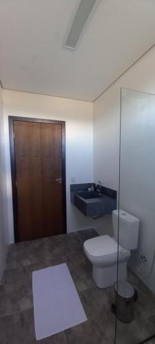 戈亚斯州上帕莱索Mangabeiras - Casa de Hóspedes的一间带卫生间和木门的浴室