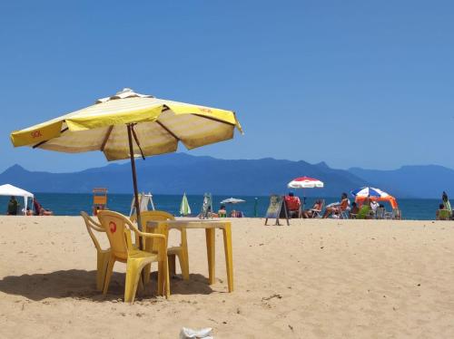 卡拉瓜塔图巴Recanto Dubay的海滩上遮阳伞下的桌椅