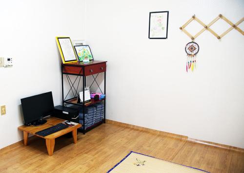蔚山Bird Village Guesthouse Rook的一间配备有书桌和一台电脑的桌子的房间