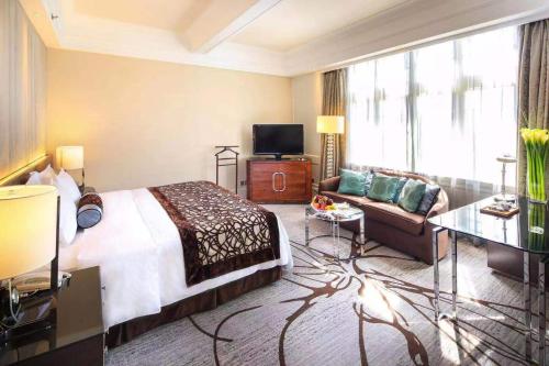 上海上海锦江饭店的酒店客房,配有床和沙发