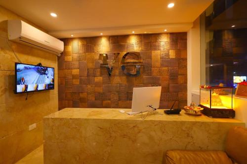 斯里卡拉哈斯蒂Hotel Vijaya Grand的客房设有带笔记本电脑的柜台和电视。