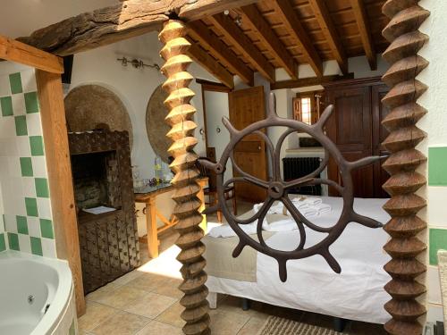 Villar de CiervoHabitaciones Rurales La Vertedera I的带壁炉的客房内的一间卧室配有一张床