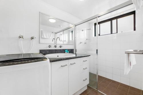 纳鲁马Apollo Unit 25 Ground Floor的白色的浴室设有水槽和淋浴。