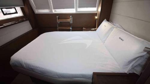 加尔维斯敦Aquamarine的一个小房间,设有一张大白色的床,带有窗户