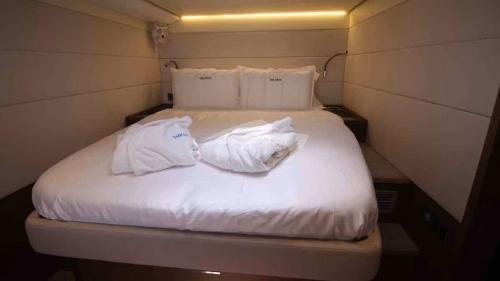 加尔维斯敦Aquamarine的小客房内的一张床位,配有白色床单和枕头