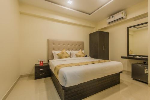 孟买Hotel Palace Inn Near Don Bosco -Borivali- Metro Station的一间卧室配有一张大床和镜子