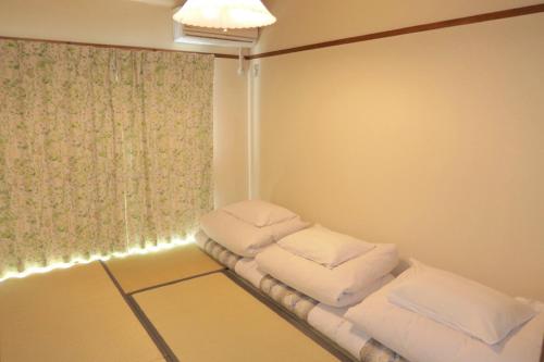 高松Aoi sora Aoi umi no guest house - Vacation STAY 86804v的一间设有三个枕头的房间,位于架子上