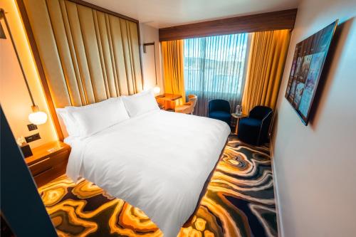 苏黎世FIVE Zurich - Luxury City Resort的酒店客房设有白色的床和窗户。