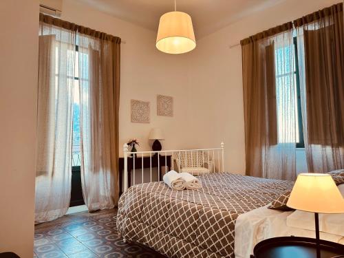 切法卢Amarea Casa Vacanze的一间卧室设有一张床和两个窗户。