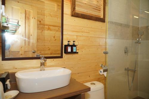波戈马洛伯格马洛海滩度假酒店的一间带水槽和玻璃淋浴的浴室