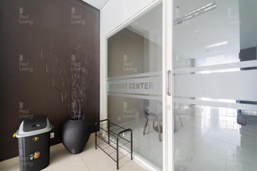 日惹RedLiving Apartemen Barsa City by Ciputra - WM Property的一间设有玻璃门、花瓶和椅子的房间