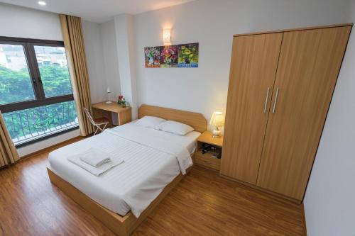 河内Granda Quan Hoa Apartment的一间卧室配有一张床和一个木制橱柜