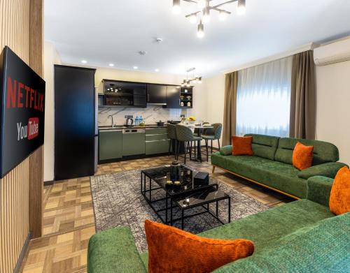伊斯坦布尔BayMari Suites City Life的一间带绿色沙发的客厅和一间厨房