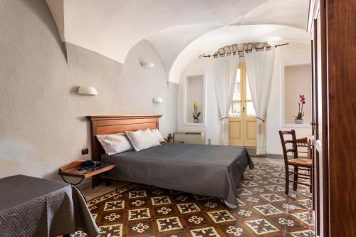 博萨Locanda di Corte的卧室配有1张床、1张桌子和1把椅子