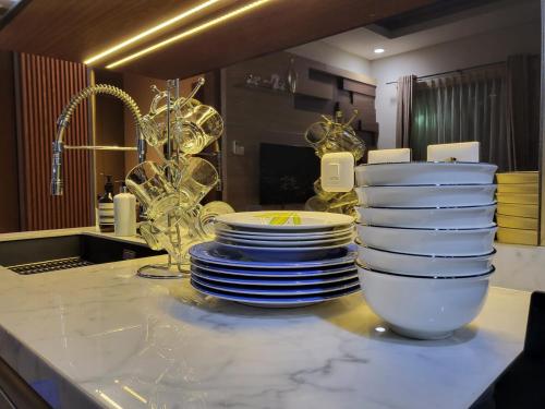 茂物Villa Vimala Hills Semeru的厨房柜台上堆放的盘子和碗