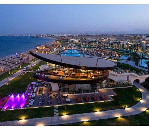 赫尔格达Rixos Premium Magawish Suites and Villas- Ultra All-Inclusive的享有带游泳池的大楼的夜间景致