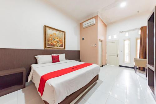 井里汶RedDoorz near Kejaksan Station Cirebon的一间卧室配有一张带红色毯子的大床