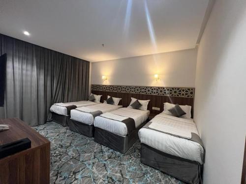 麦加فندق بياك أوتيل الروضة的一间酒店客房,房间内设有三张床
