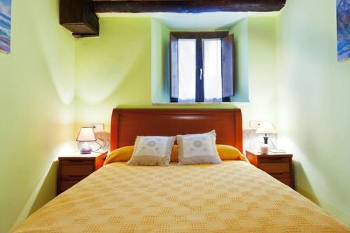 SevaresApartamentos Casa Margot的一间卧室配有一张带2个床头柜的大床