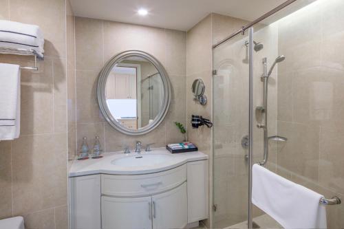 芽庄Meliá Vinpearl Nha Trang Empire的浴室配有盥洗盆和带镜子的淋浴