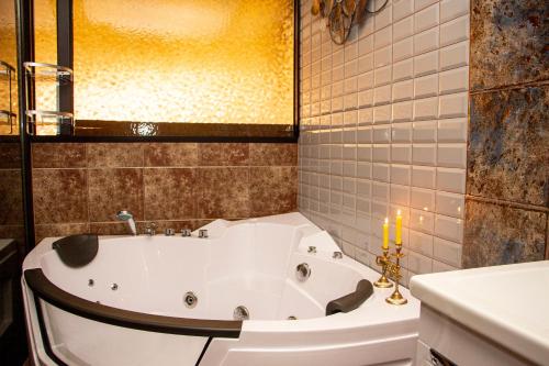 巴统Batumi West Hotel的浴室内配有带蜡烛的浴缸。