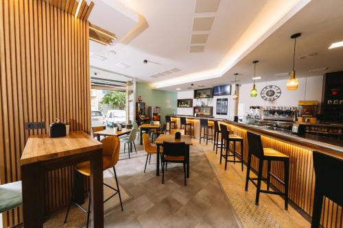 塞埃Hotel Oca Insua Costa da Morte的餐厅设有酒吧,配有桌椅