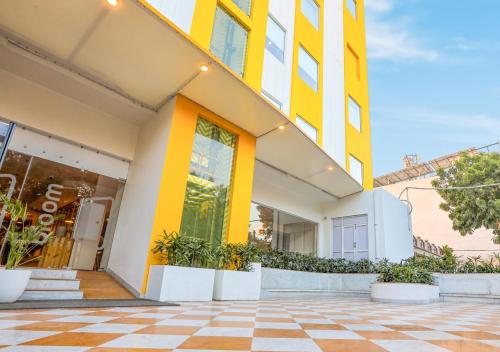 贾朗达尔Bloom Hotel - Jalandhar的黄色和白色的建筑,铺有瓷砖地板