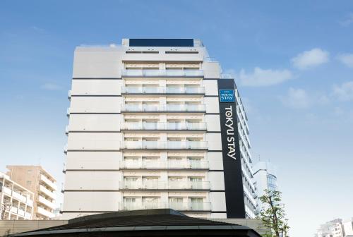 东京涩谷新南口东急酒店的一座高大的白色建筑,上面有标志