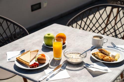 雅典Dunlin Hotel的餐桌,盘子和一杯橙汁