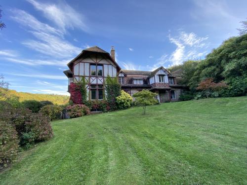 Vattetot-sur-MerLe Manoir by CauxCottes的一座大房子,位于一座小山上,拥有绿色庭院