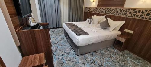 麦加فندق بياك أوتيل الروضة的酒店客房,配有一张带两个天鹅的床