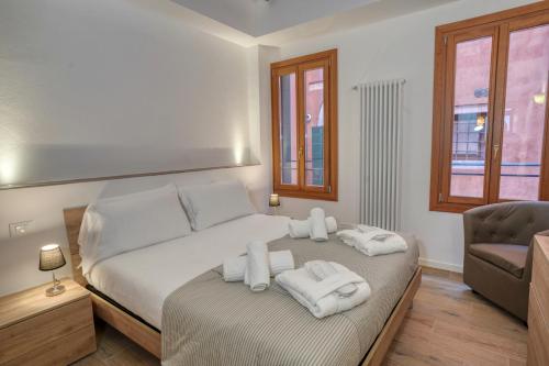 威尼斯Ecco Suites Apartments的一间卧室配有带毛巾的床