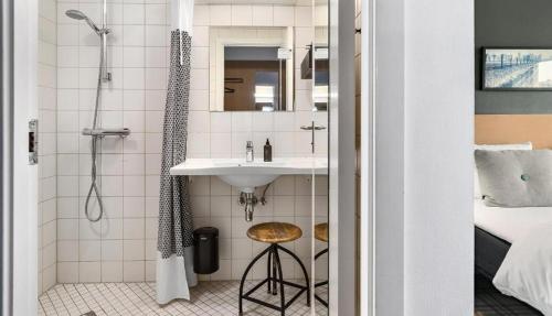 哥本哈根易卜生酒店的一间带水槽和淋浴的浴室
