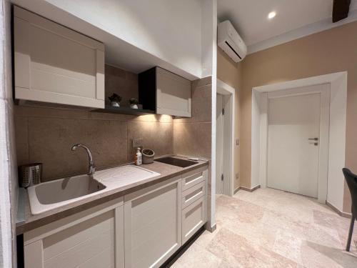 卡斯塔涅托卡尔杜奇Mia Margot Suite Apartment的厨房配有白色橱柜和水槽