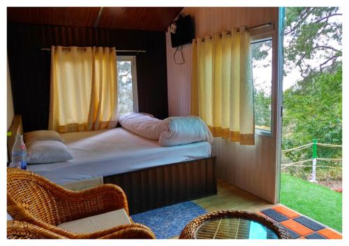奈尼塔尔The Cocoon Camps & nature Resorts的一间卧室设有一张床和一个带游泳池的窗户