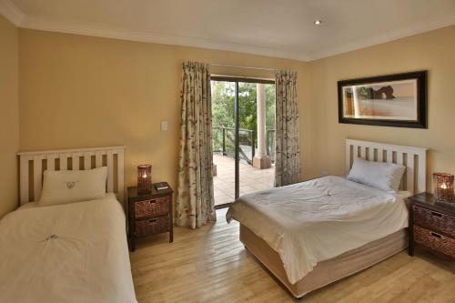 兰格班Galico Holiday Home的一间卧室设有两张床和滑动玻璃门