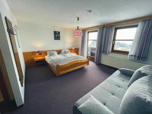 米尔施塔特兰玛斯多尔夫客栈酒店的一间卧室配有一张床和一张沙发