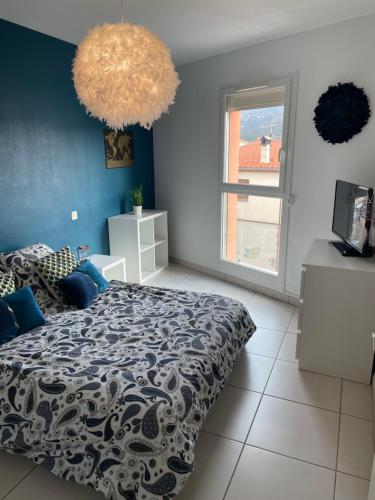 勒宝洛Appartement T3 climatisé,balcon的一间卧室设有一张床和蓝色的墙壁