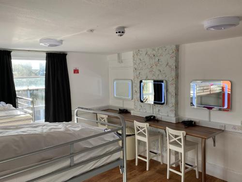 巴斯Bath YMCA Hostel的一间卧室配有一张床、一张书桌和一面镜子