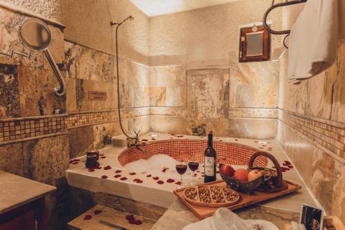 格雷梅玛肯洞穴酒店的带浴缸和一瓶葡萄酒的浴室